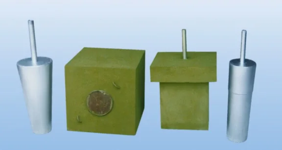 Porous plug assortment on a pale blue backdrop: a tapered and a cylindrical steel-jacketed plug with gas inlet tubes, and two square-section green refractory plug blocks