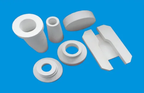 White refractory casting components: sprue cups, sleeves, flanged rings, a disc and a slotted plate