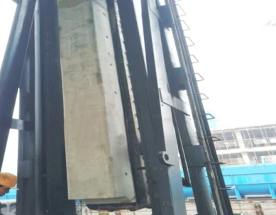Close view of a precast lining block mounted on a vertical coke oven door frame