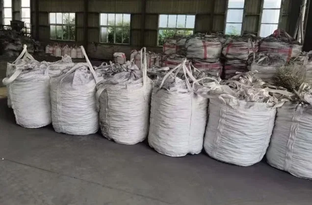 Row of filled jumbo bags on the floor of a storage shed