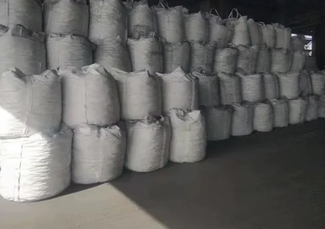 Filled jumbo bags stacked several high in a warehouse